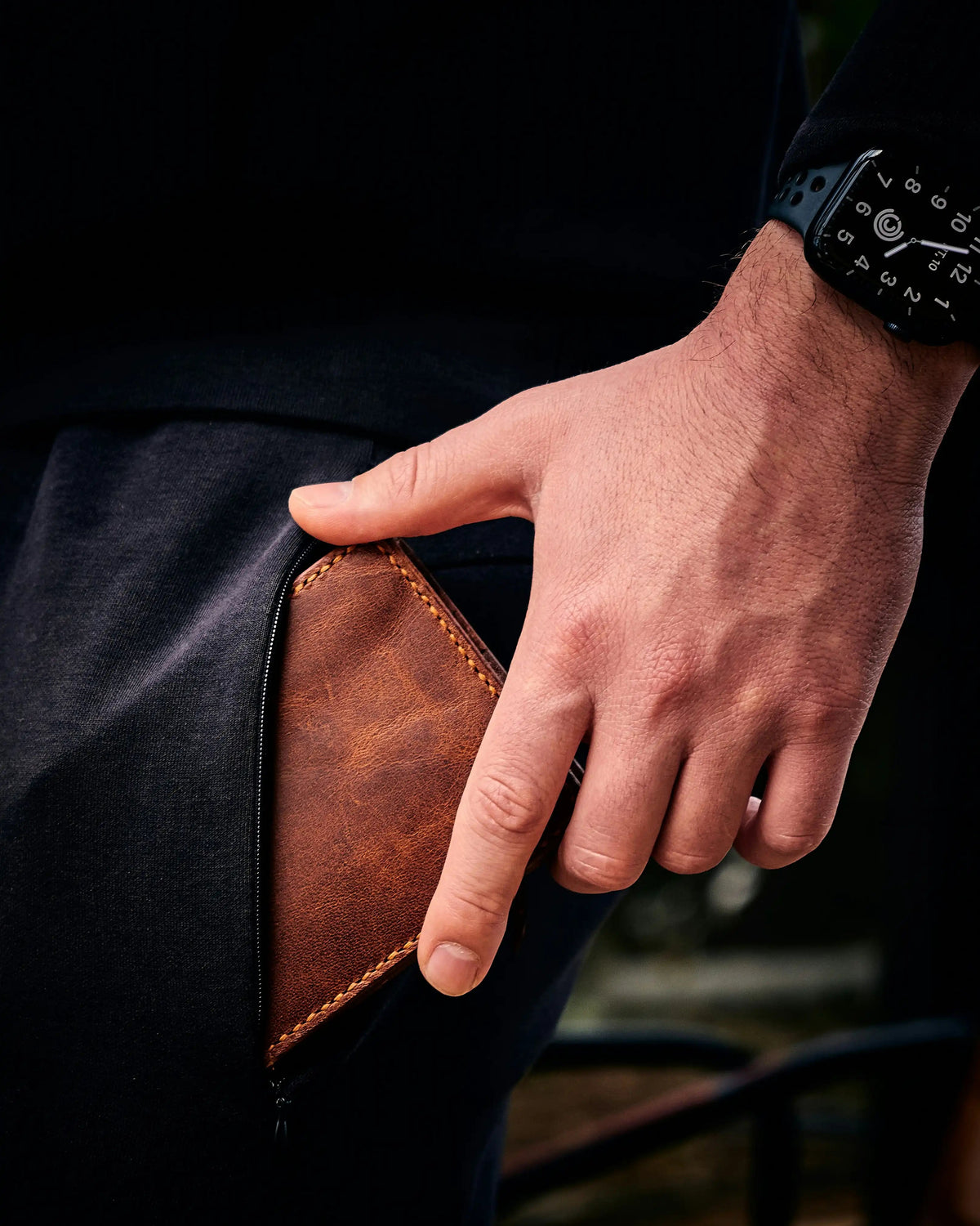 Hand holding a leather-bound book against a dark background
